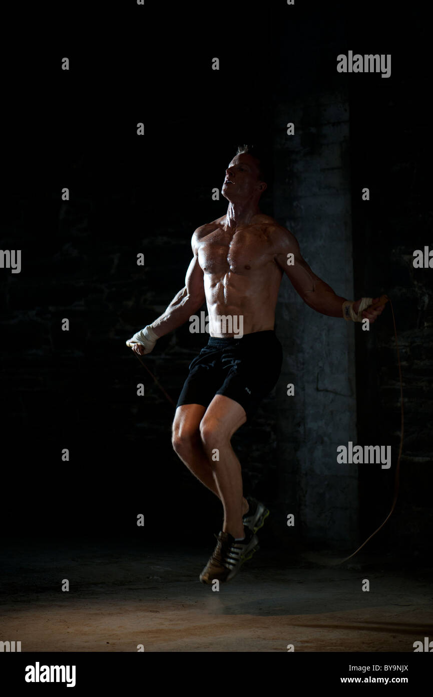 Una adatta fisicamente uomo esercitando con un salto con la corda Foto Stock