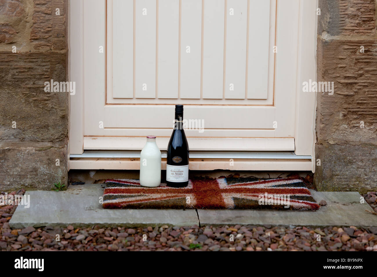 Una bottiglia di latte ed un bottiglia di vino su una porta con