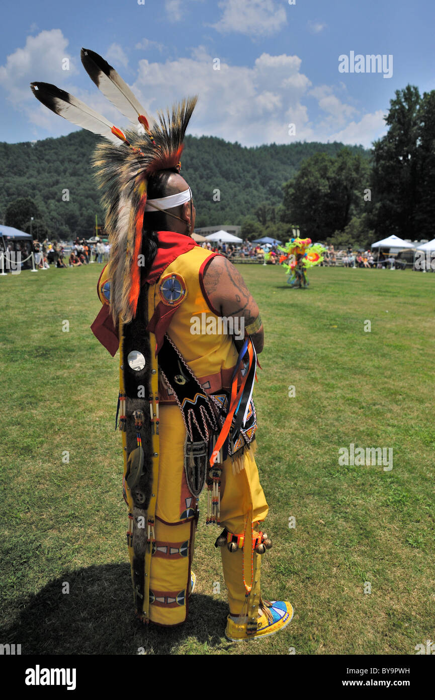 Un tatuato Pow Wow dancer che indossa due Eagle piume sorge in corrispondenza del bordo dell'anello di danza in Cherokee, Carolina del Nord Foto Stock