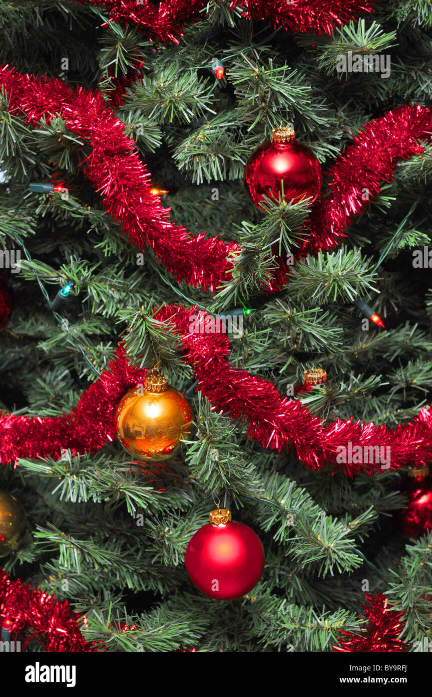 Albero di natale tinsel wrap e ornamenti in vetro su albero con luci Foto Stock
