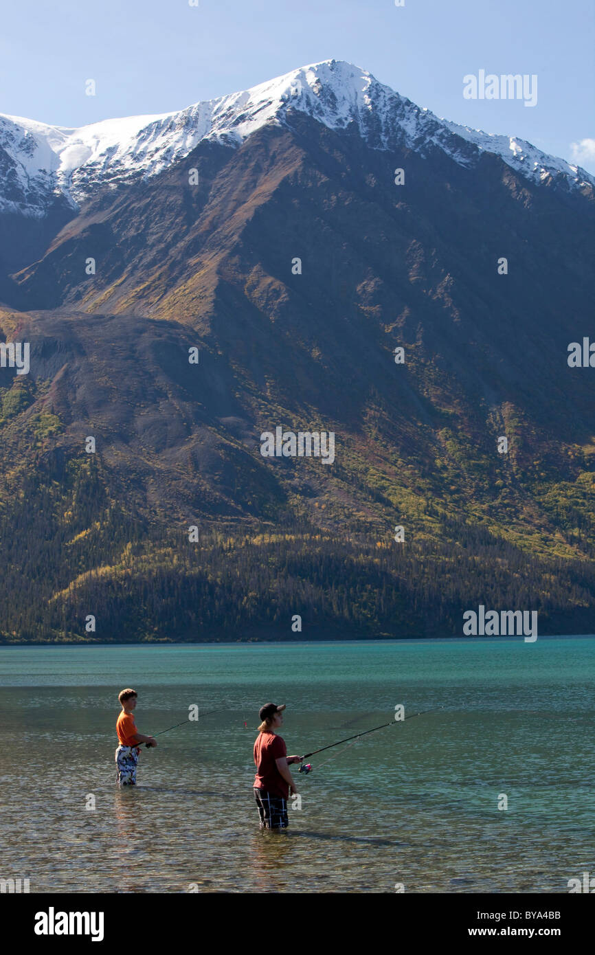 I bambini e i ragazzi, i piedi in acqua poco profonda, pesca a Kathleen Lake, re sul trono dietro, St. Elias Montagne Foto Stock