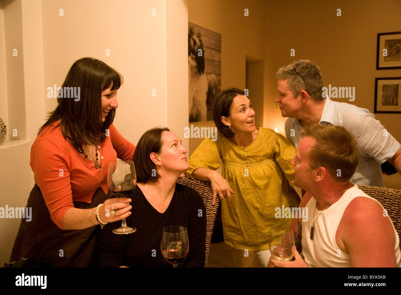 Gruppo con bicchieri di vino in chat su tavola di cena Foto Stock