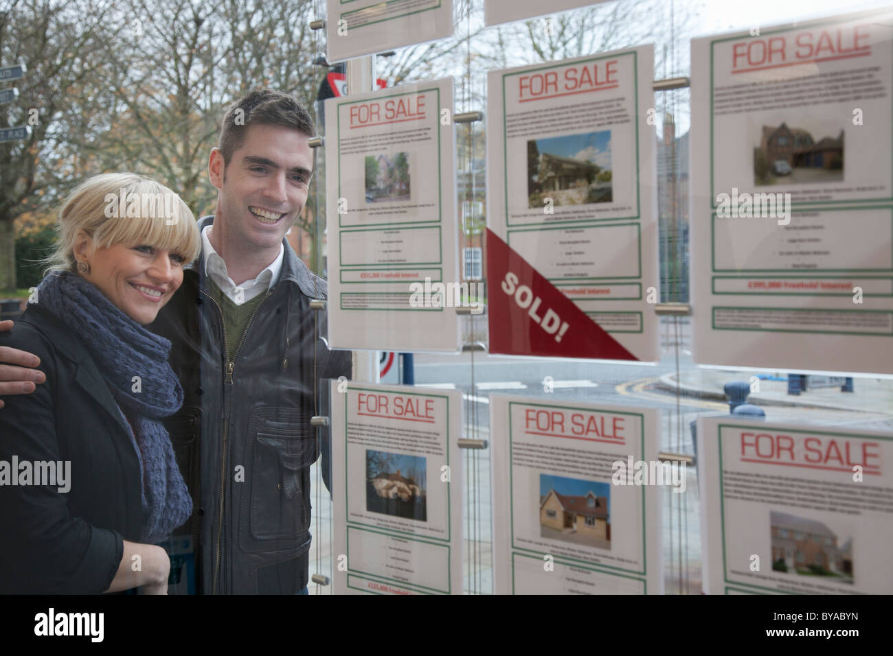 Giovane cercando in agenti immobiliari finestra Foto Stock