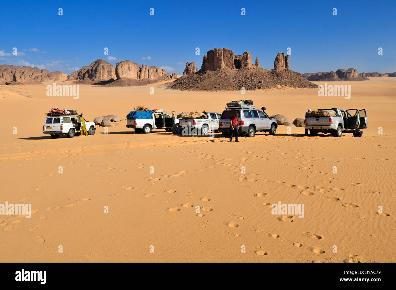Veicoli turistici in corrispondenza del Tassili n'Ajjer National Park, sito Patrimonio Mondiale dell'Unesco, la regione di Tikobaouine vicino Erg Admer, Wilaya di Illizi Foto Stock
