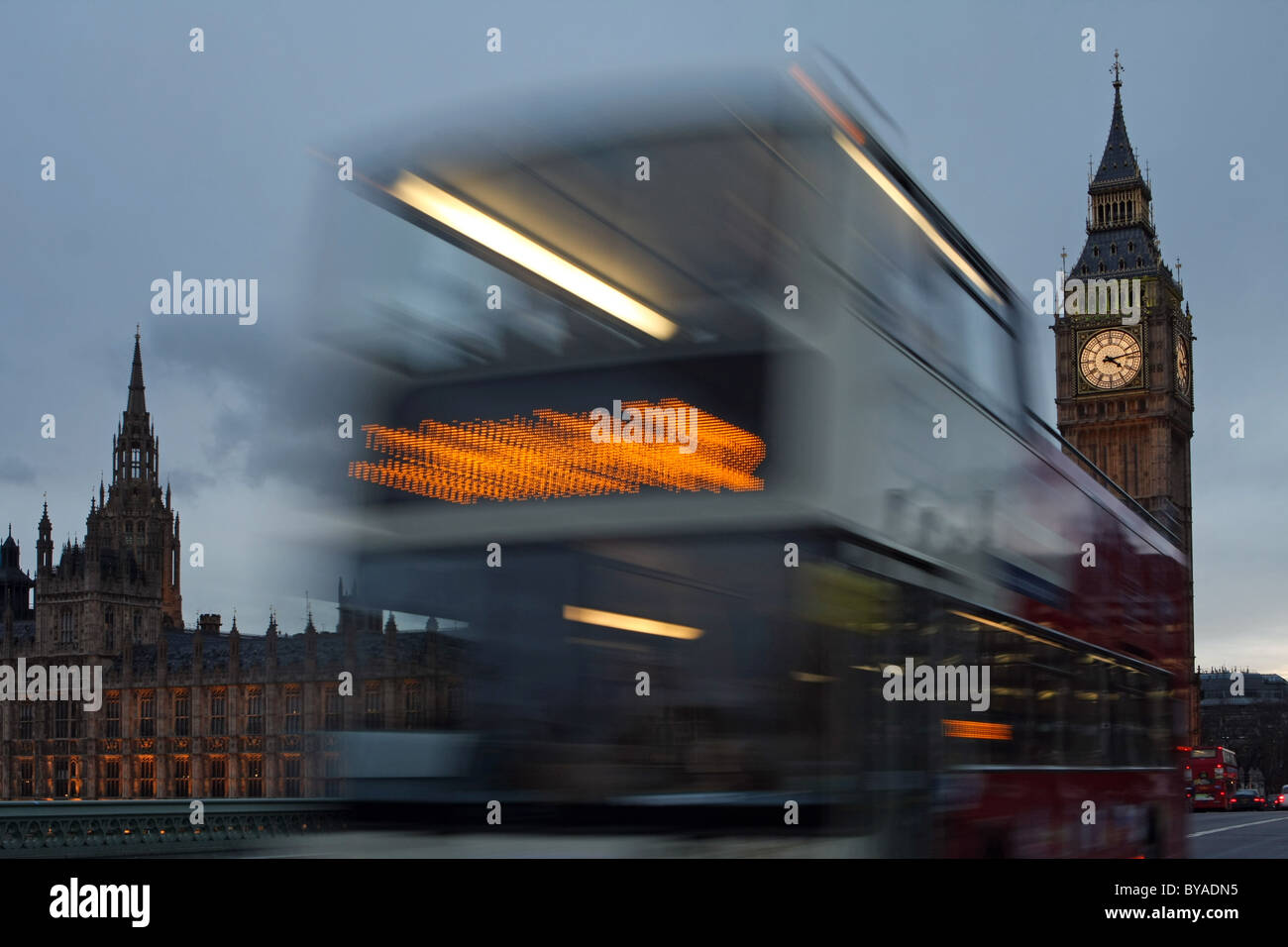 Un London Tour bus passando davanti alla Casa del Parlamento di sera Foto Stock