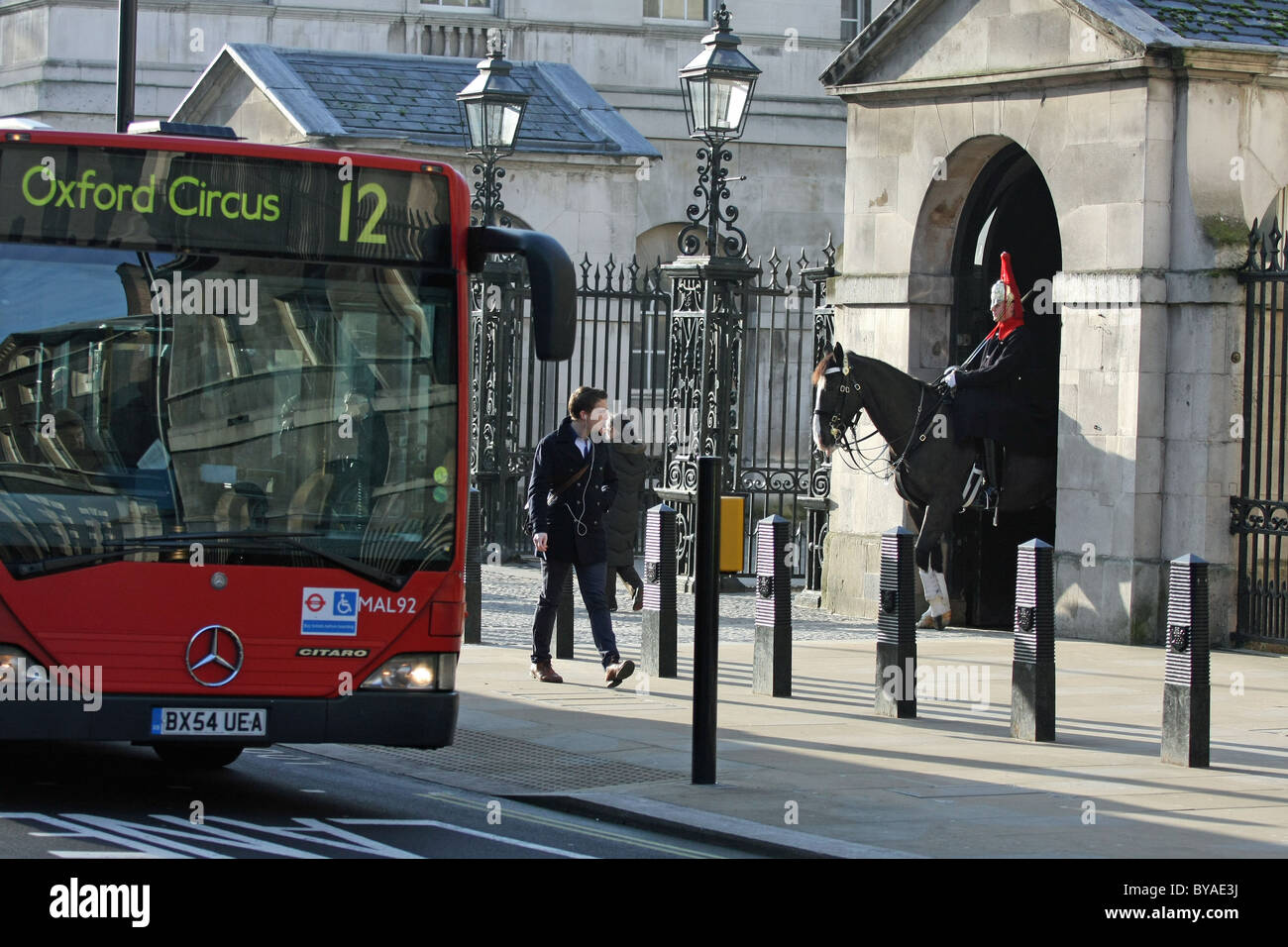 Uno di Regina della vita delle guardie sul dovere con un bus di Londra e alcune persone di passaggio Foto Stock