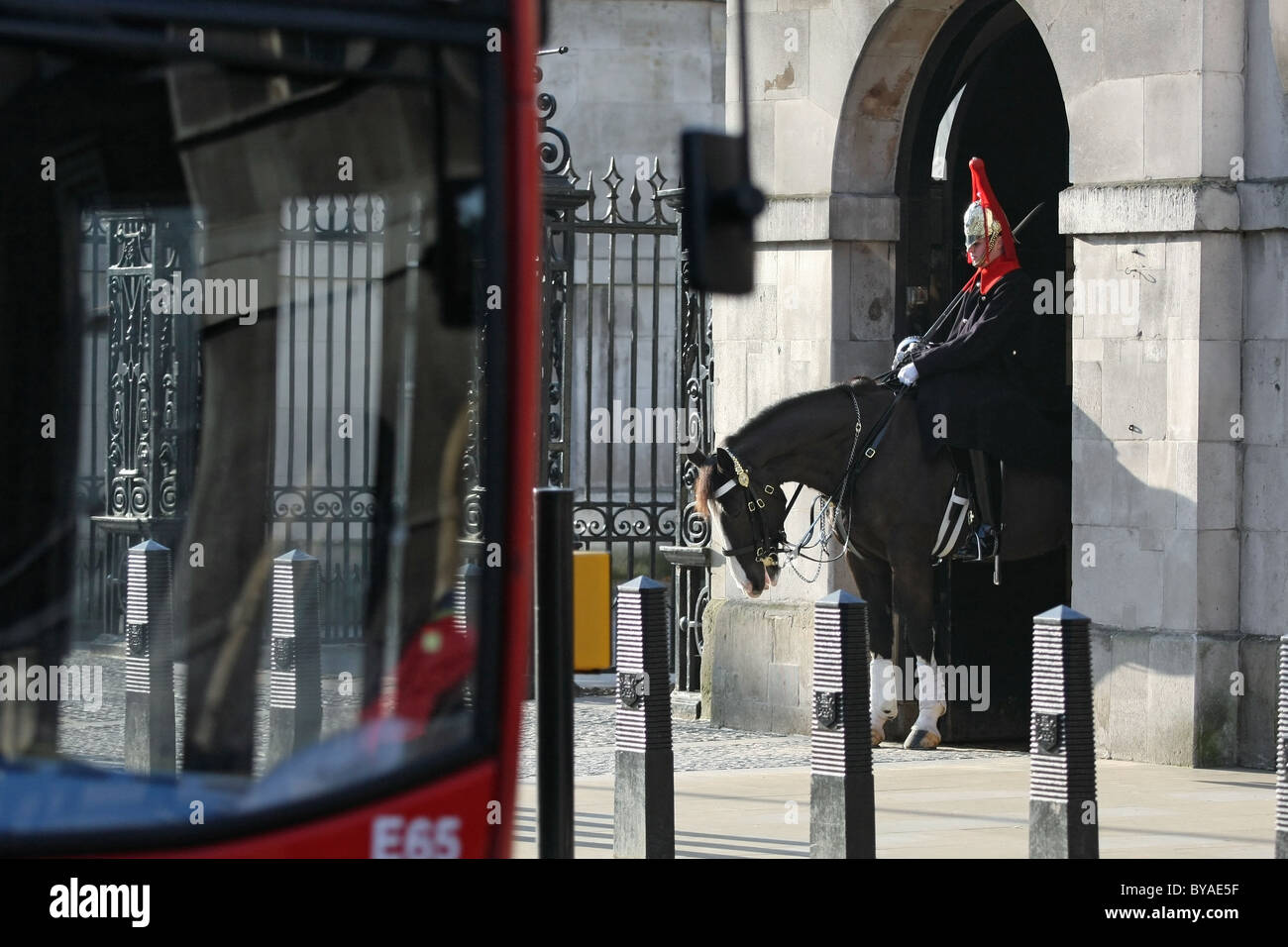 Uno di Regina della vita delle guardie sul dovere con un bus londinese passando Foto Stock