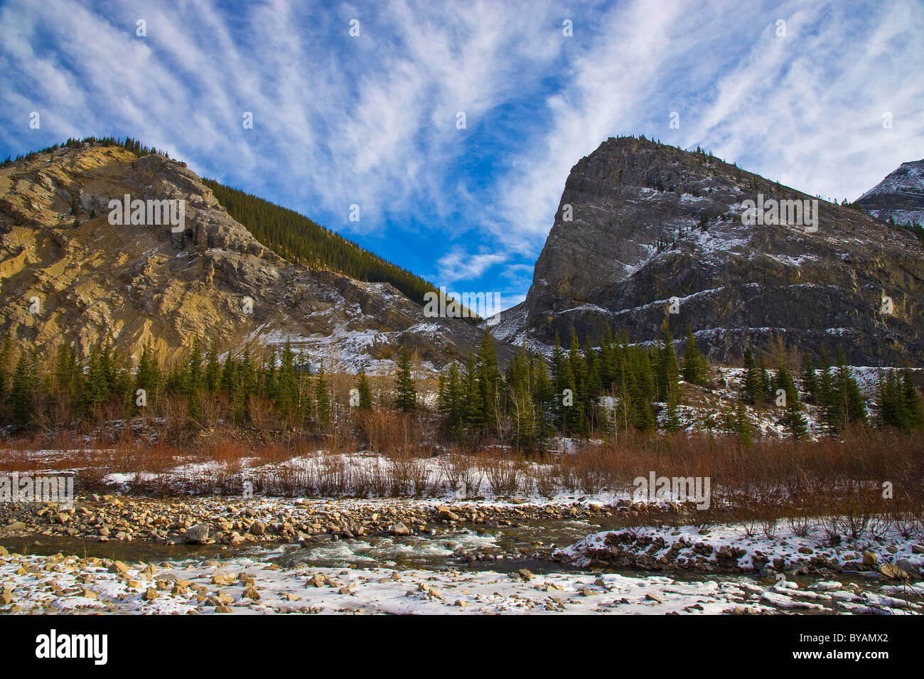Un piano orizzontale di paesaggio invernale immagine del fiume McLeod e il circostante Rocky Mountain Range. Foto Stock