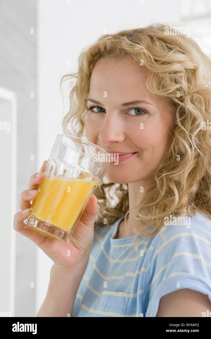 Donna di bere succo di arancia Foto Stock