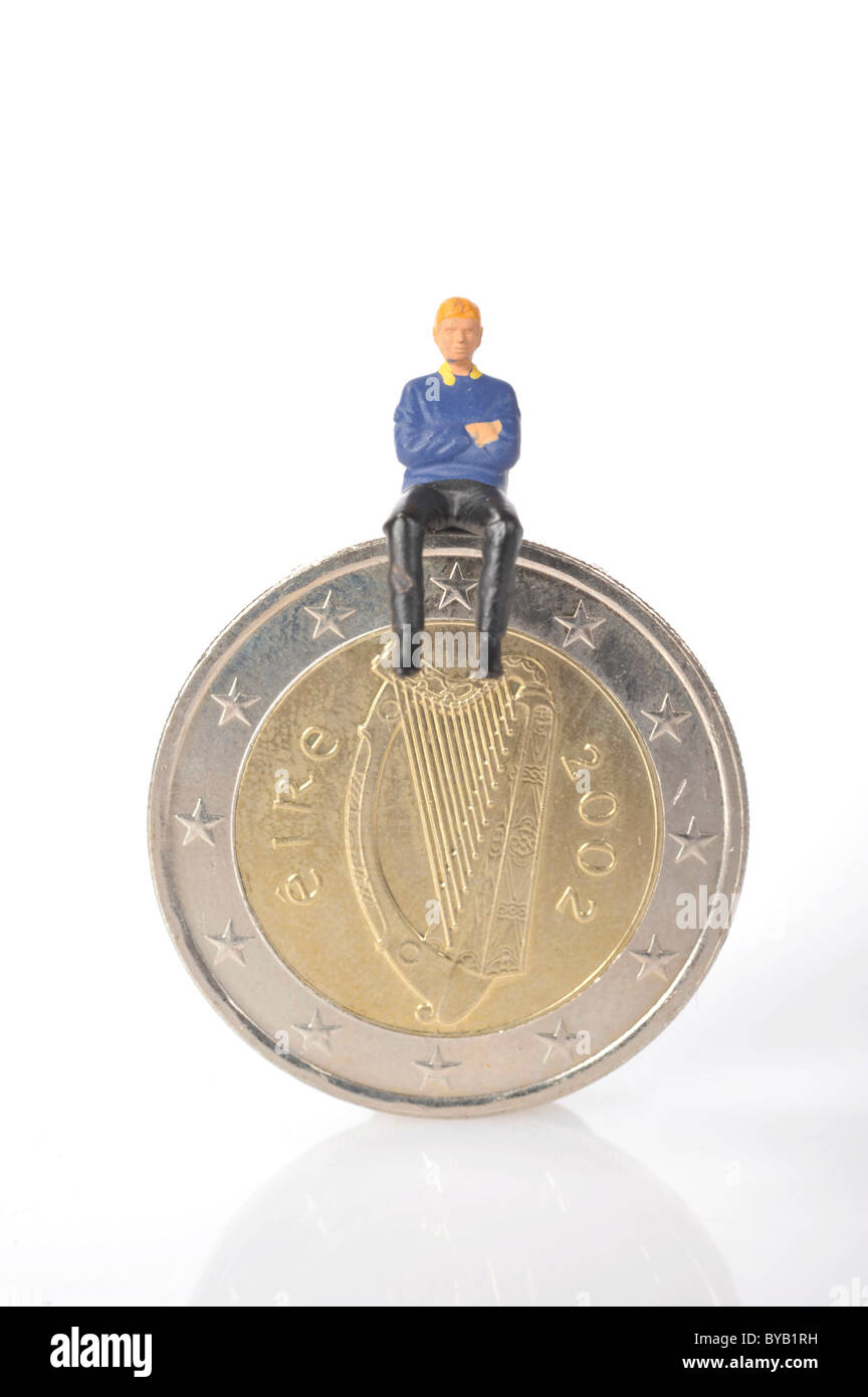 Figurina seduta su Irish Euro moneta, immagine simbolica per la crisi finanziaria in Irlanda Foto Stock