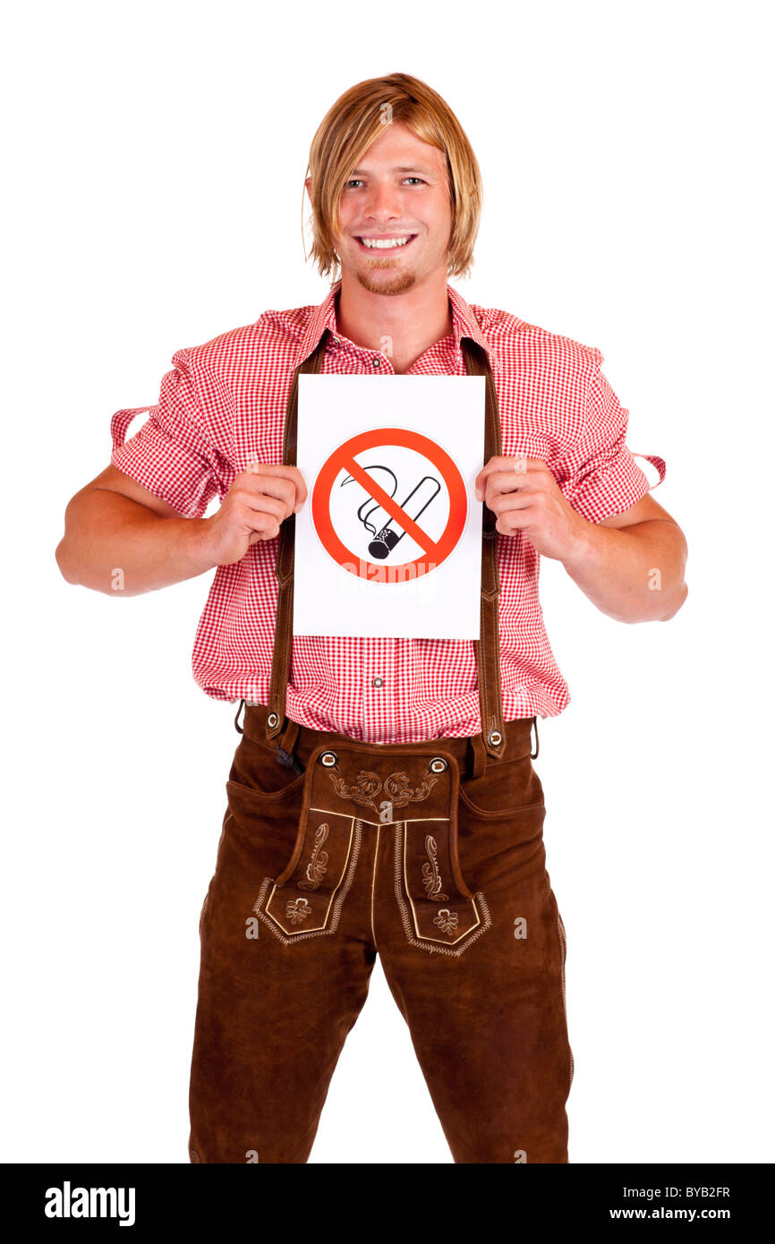 Sorridente uomo bavarese in lederhose detiene il non-fumatori-regola segno. Isolato su sfondo bianco. Foto Stock