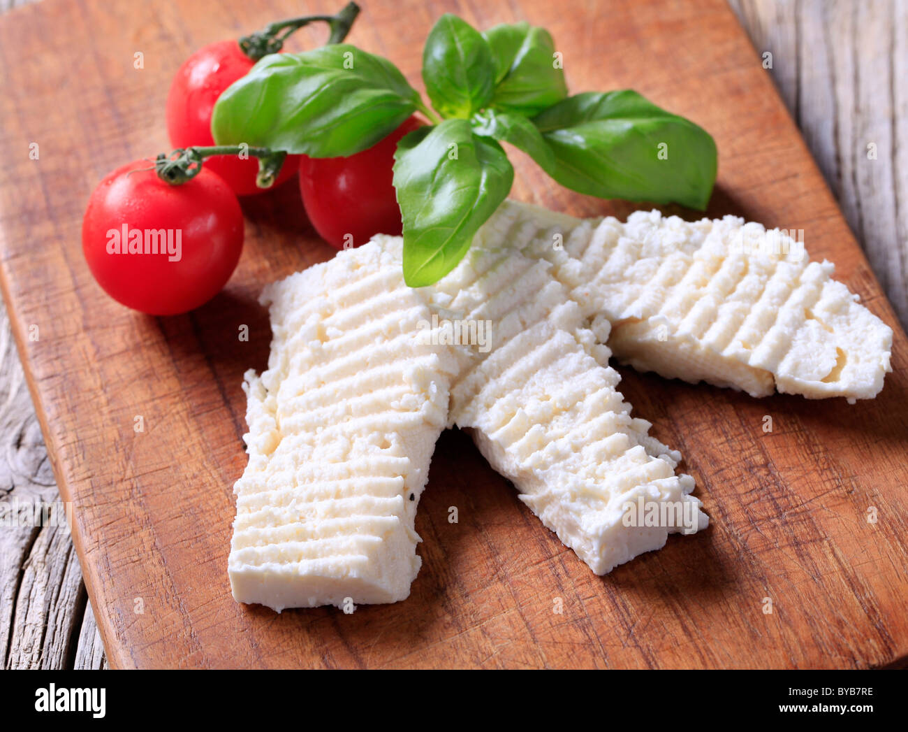 Fette di formaggio su un tagliere Foto Stock