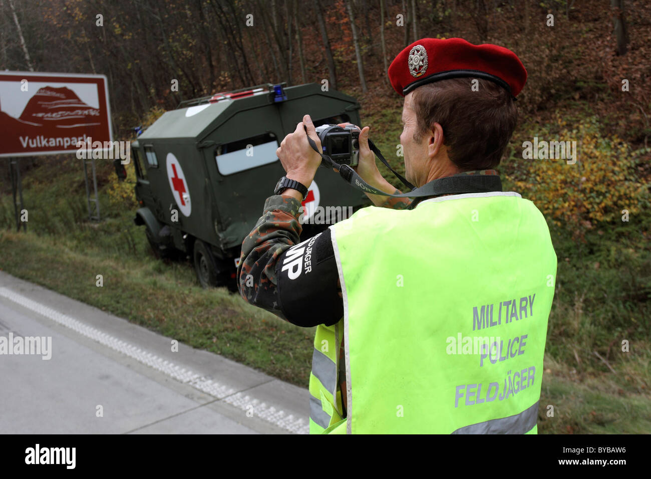 Feldjaeger, un poliziotto militare della Bundeswehr, Germania delle forze armate, documentando la scena di un incidente con un militare Foto Stock