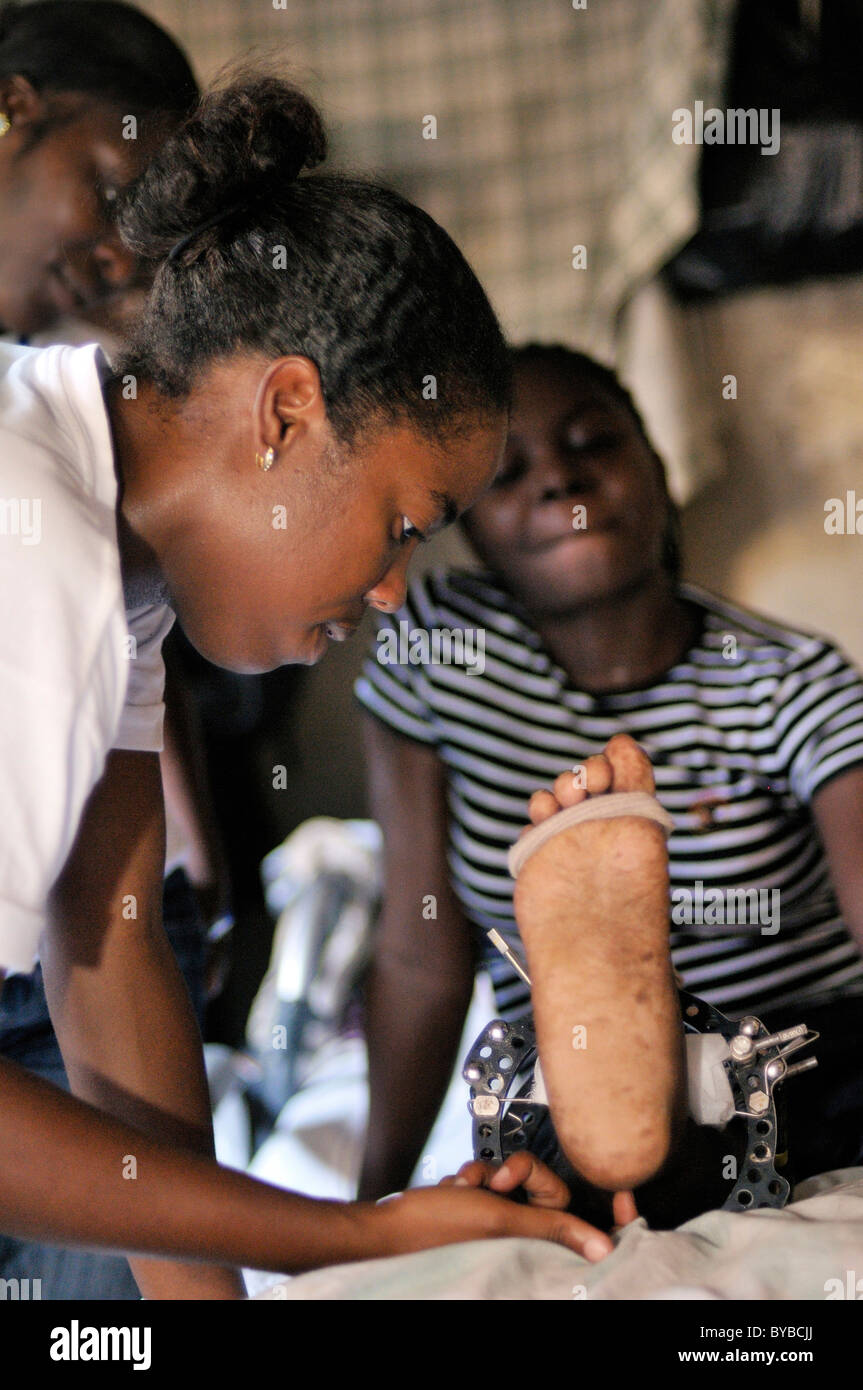 Giovane donna feriti nel gennaio 2010 terremoto fisioterapista ricevere supporto da un organizzazione di sfiato Foto Stock