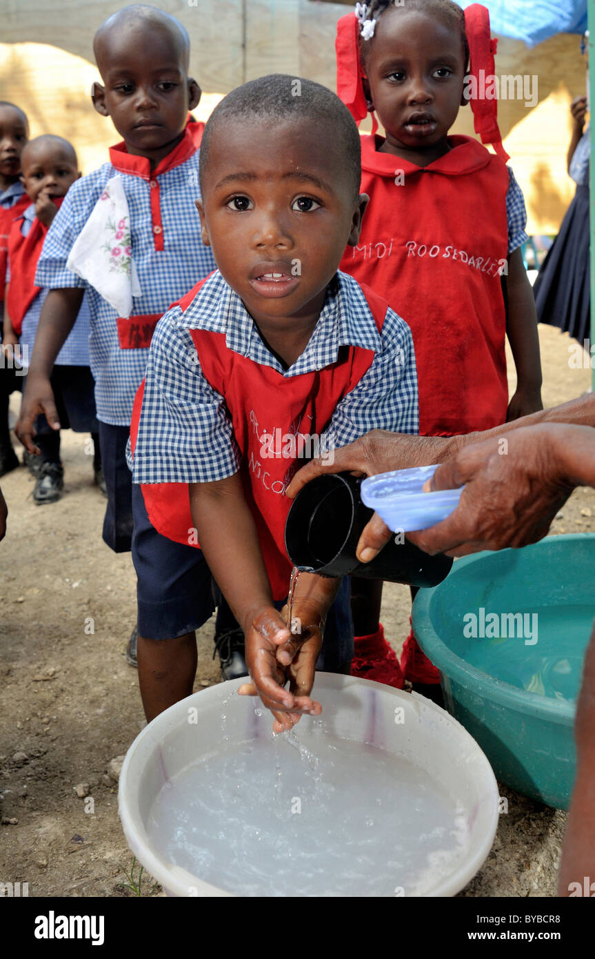 Come prevenzione contro il colera infezioni, i bambini imparano a lavarsi le mani in una scuola materna, , Haiti, dei Caraibi Foto Stock