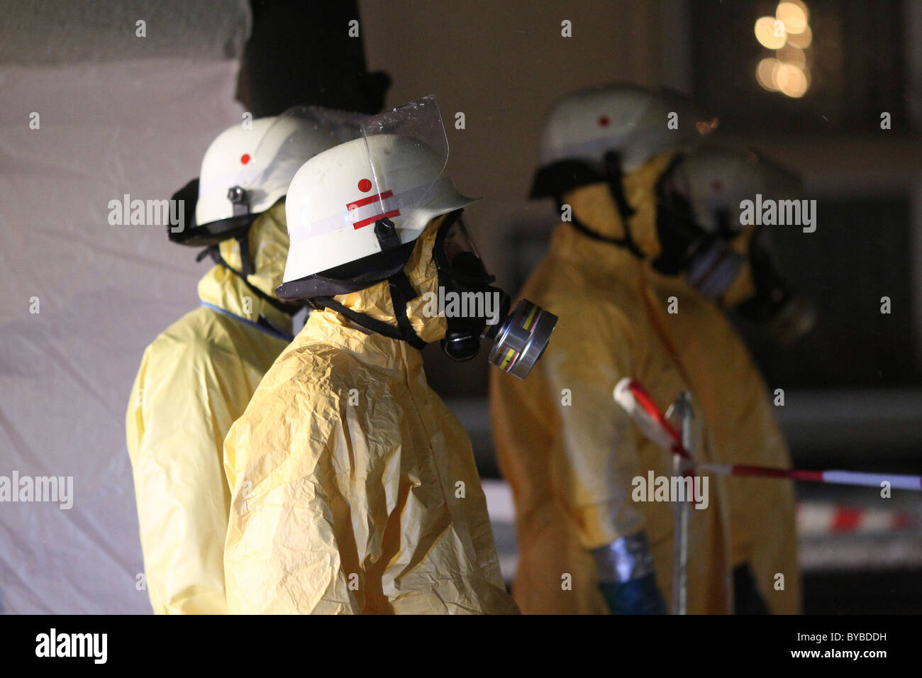I vigili del fuoco in dotazione per il contenimento di sostanze pericolose indossando indumenti protettivi, caschi e maschere respiratore Foto Stock