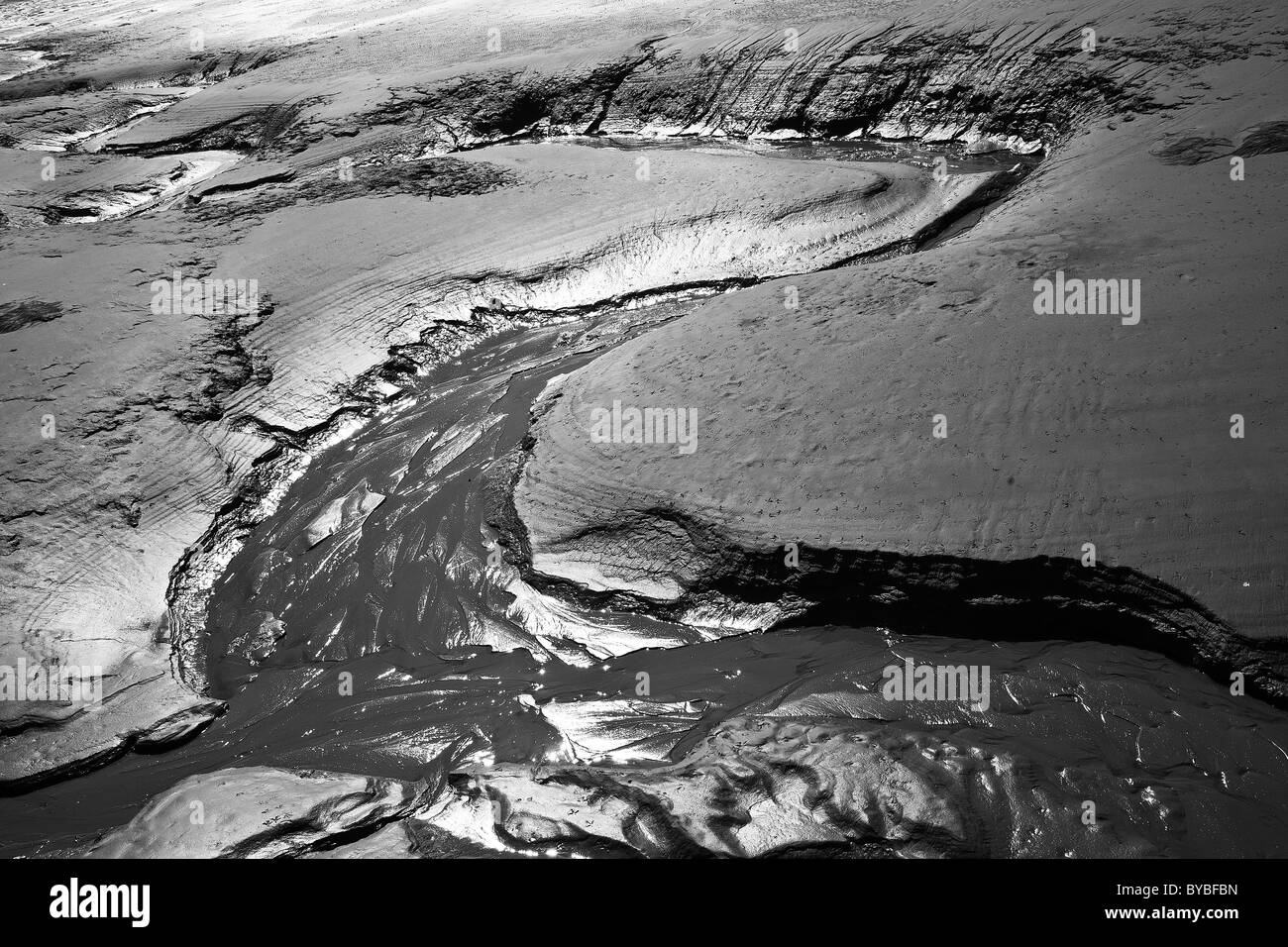 S a forma di canale di acqua nel fango di marea Foto Stock