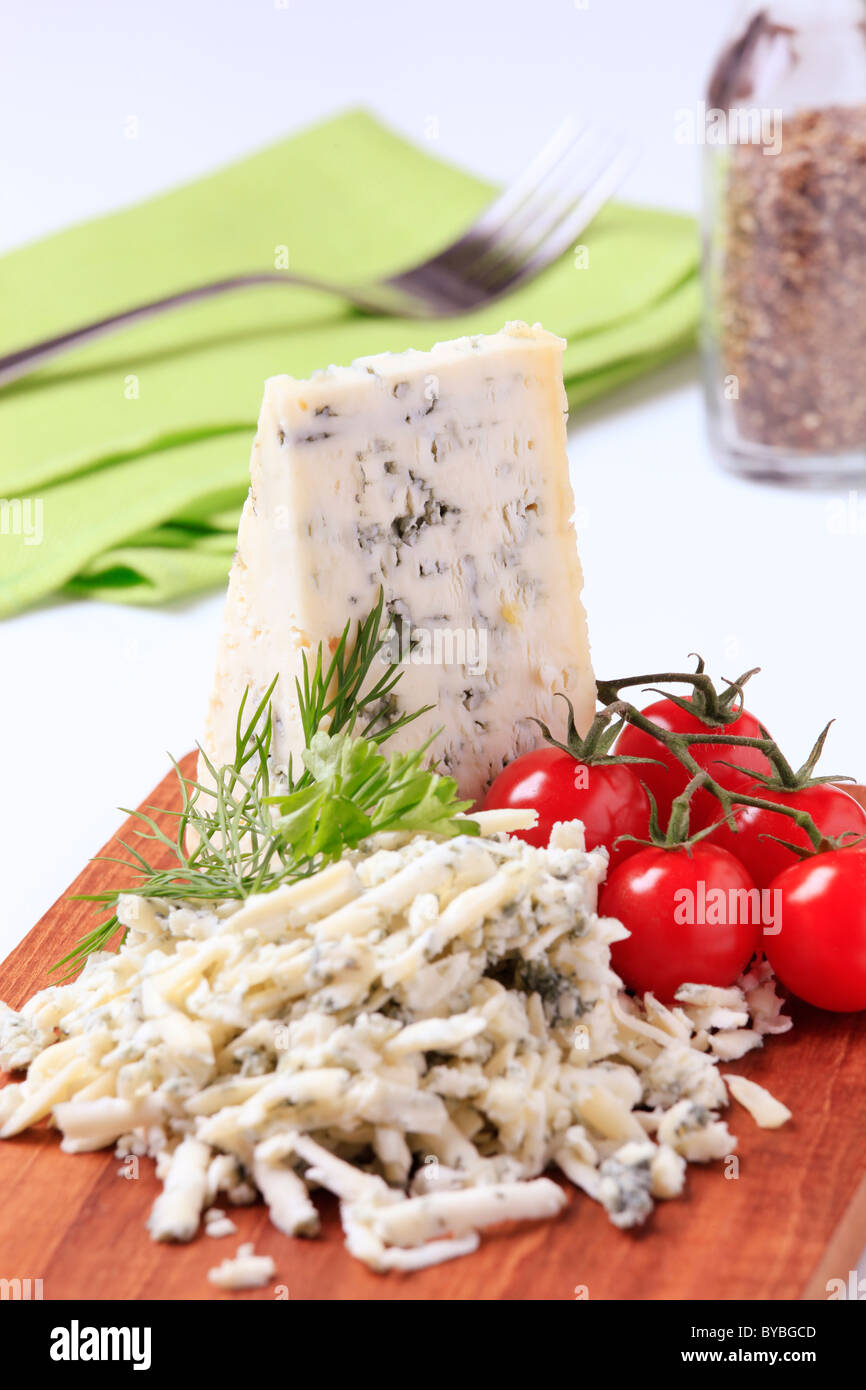 Formaggio blu e pomodori freschi su un tagliere Foto Stock