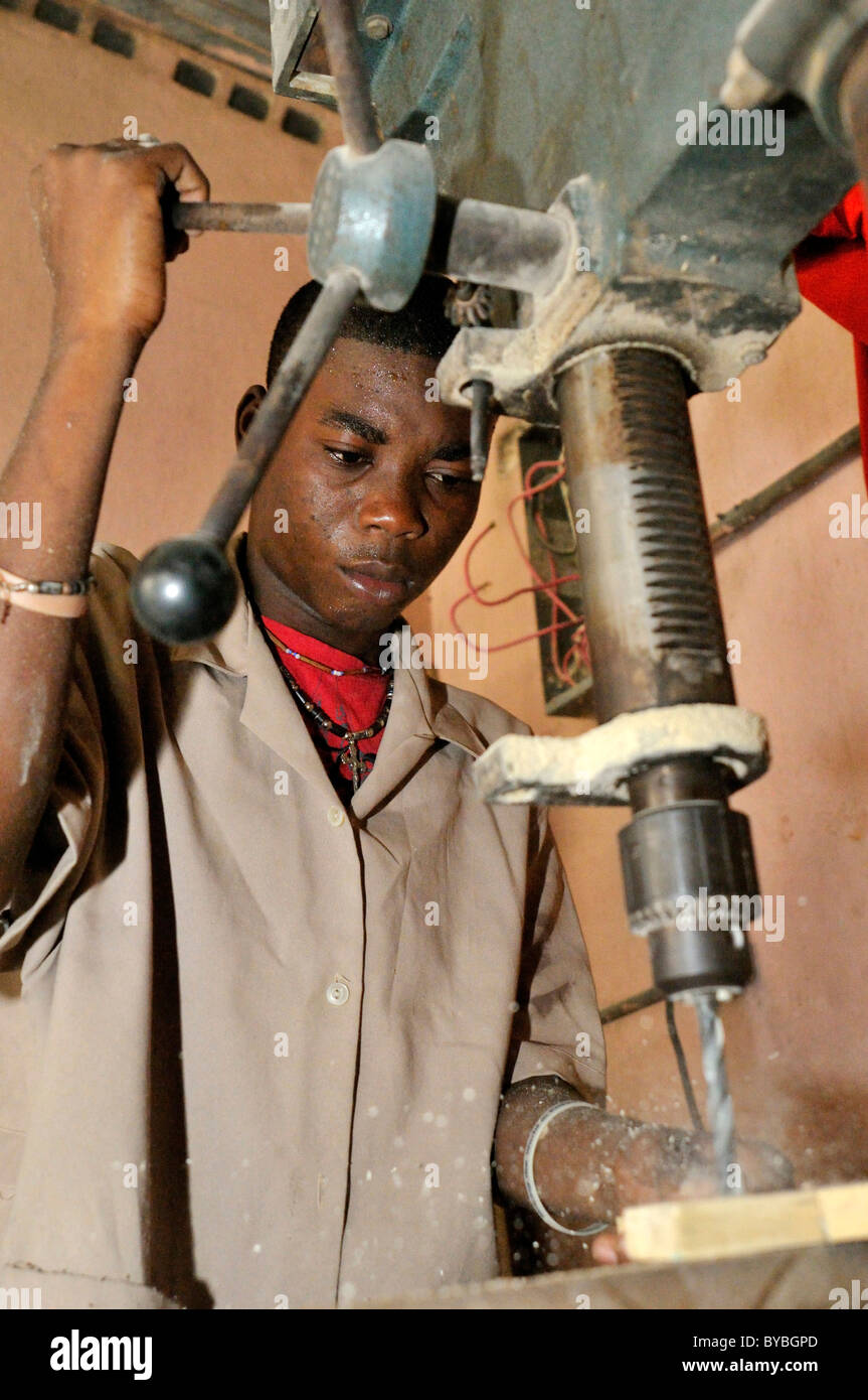 Giovane uomo servendosi di un trapano, un corso di formazione per la falegnameria per i giovani della Cité Soleil baraccopoli, progetto salesiano Lakay o Foto Stock