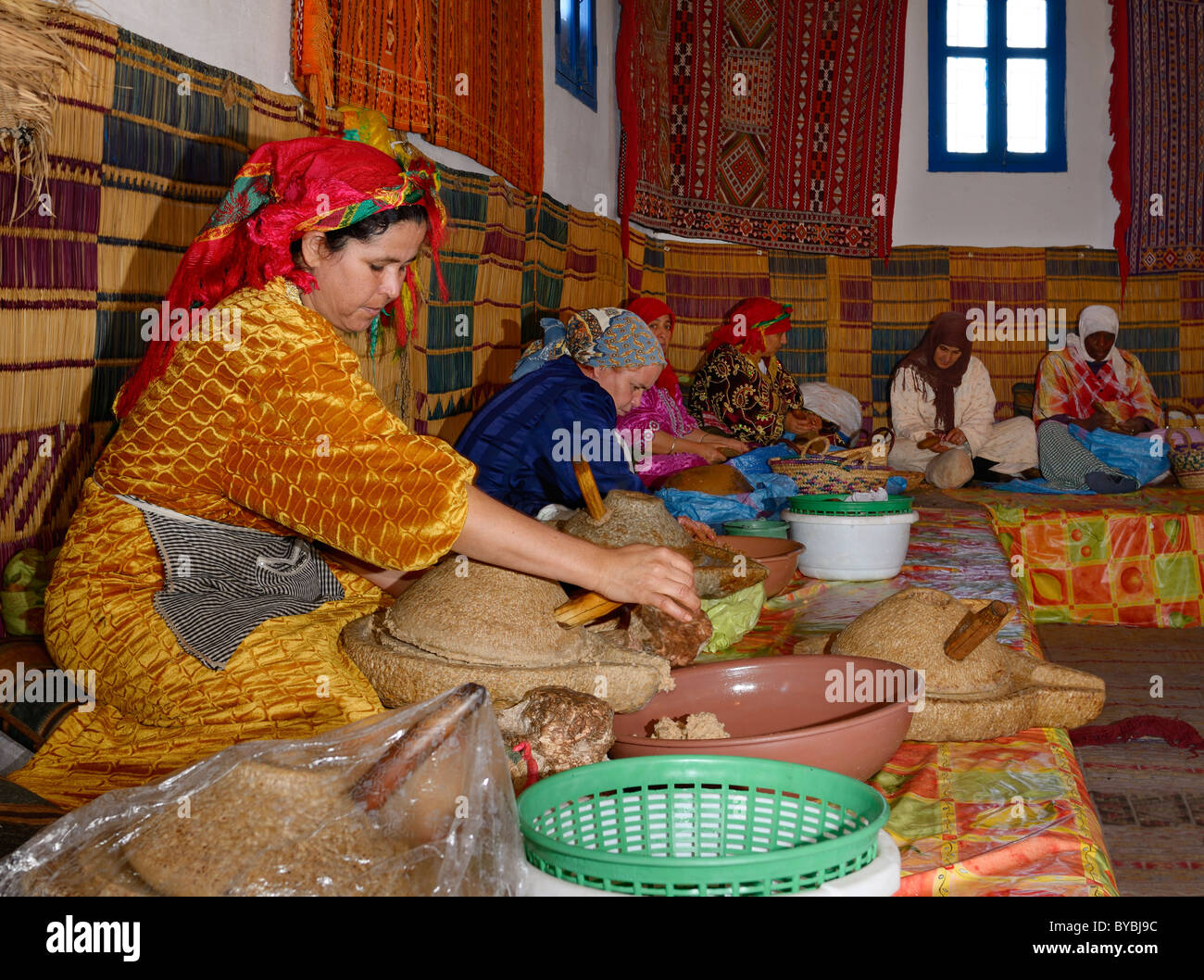 Womens marocchino cooperativa a afous argane rendendo l'olio di argan a mano in una linea di produzione del Marocco Foto Stock