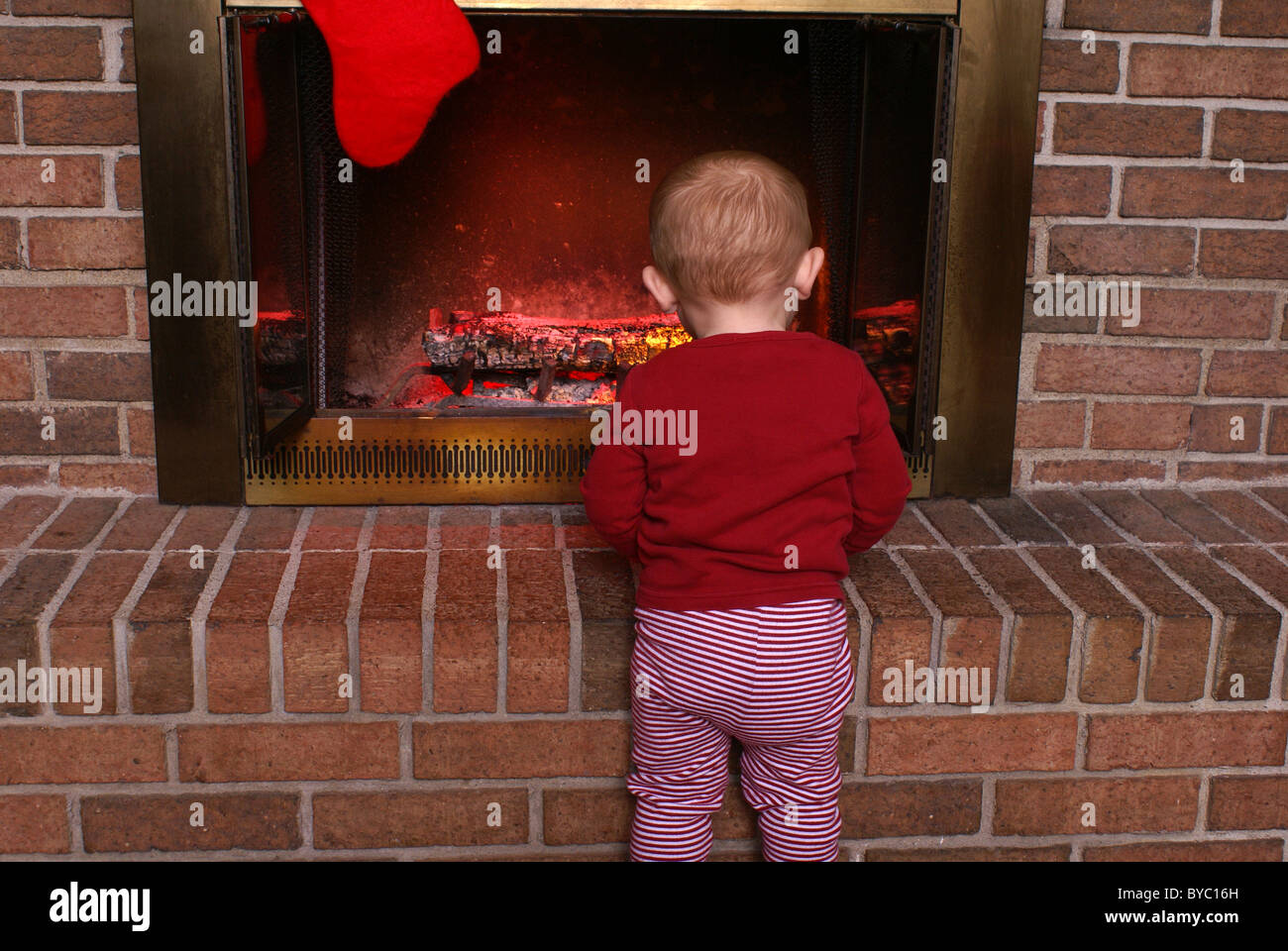 Bambino al camino in attesa di Santa. Foto Stock