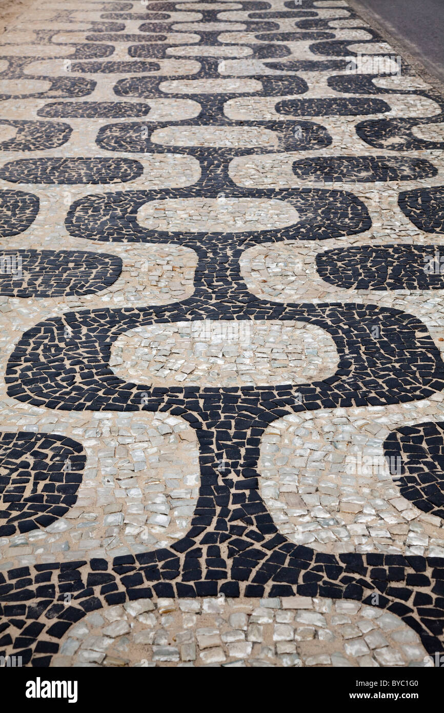 La pavimentazione portoghese presso la spiaggia di Ipanema marciapiede, a Rio de Janeiro, Brasile, Sud America. Foto Stock