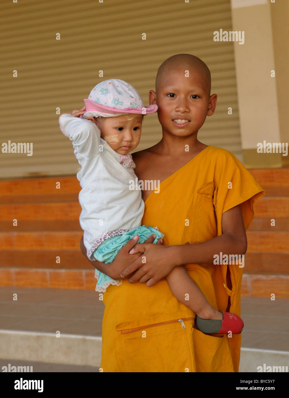Giovane debuttante tenendo la sua sorella baby ,Wat Chumphon Khiri (Chumphon Khiri Tempio), Mae Sot (mae sod) , a nord est della Thailandia Foto Stock