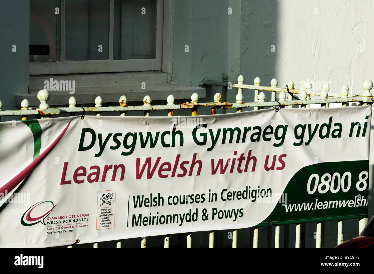 Cartello bilingue pubblicità Welsh corsi di lingua per adulti in Aberystwyth, Galles Foto Stock