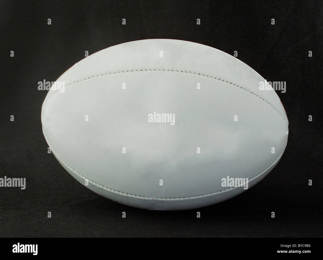 Una lite grigio palla da rugby su nero Foto Stock