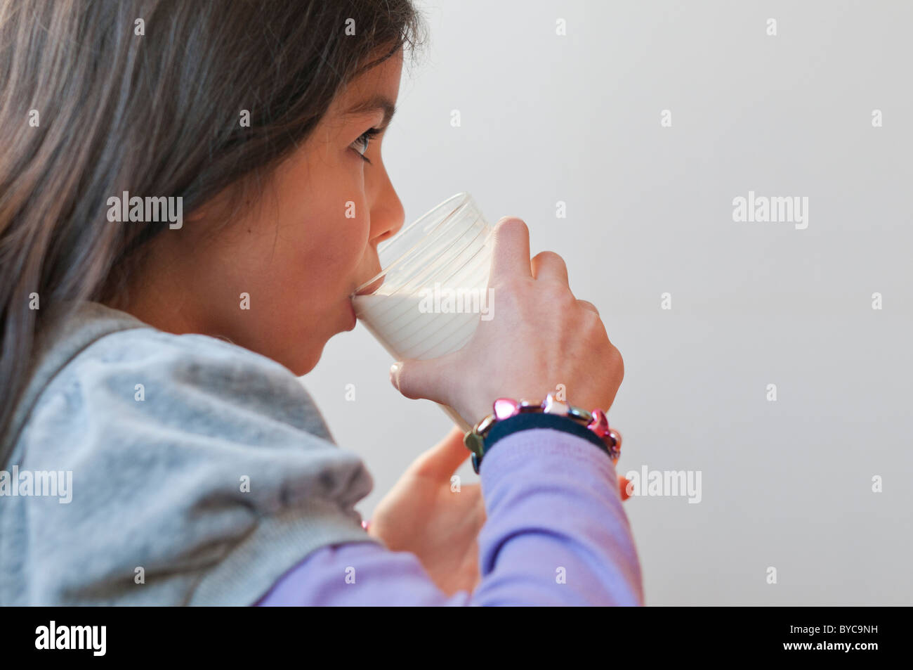 Ragazza, età 9-drink fresco latte vista lato Foto Stock