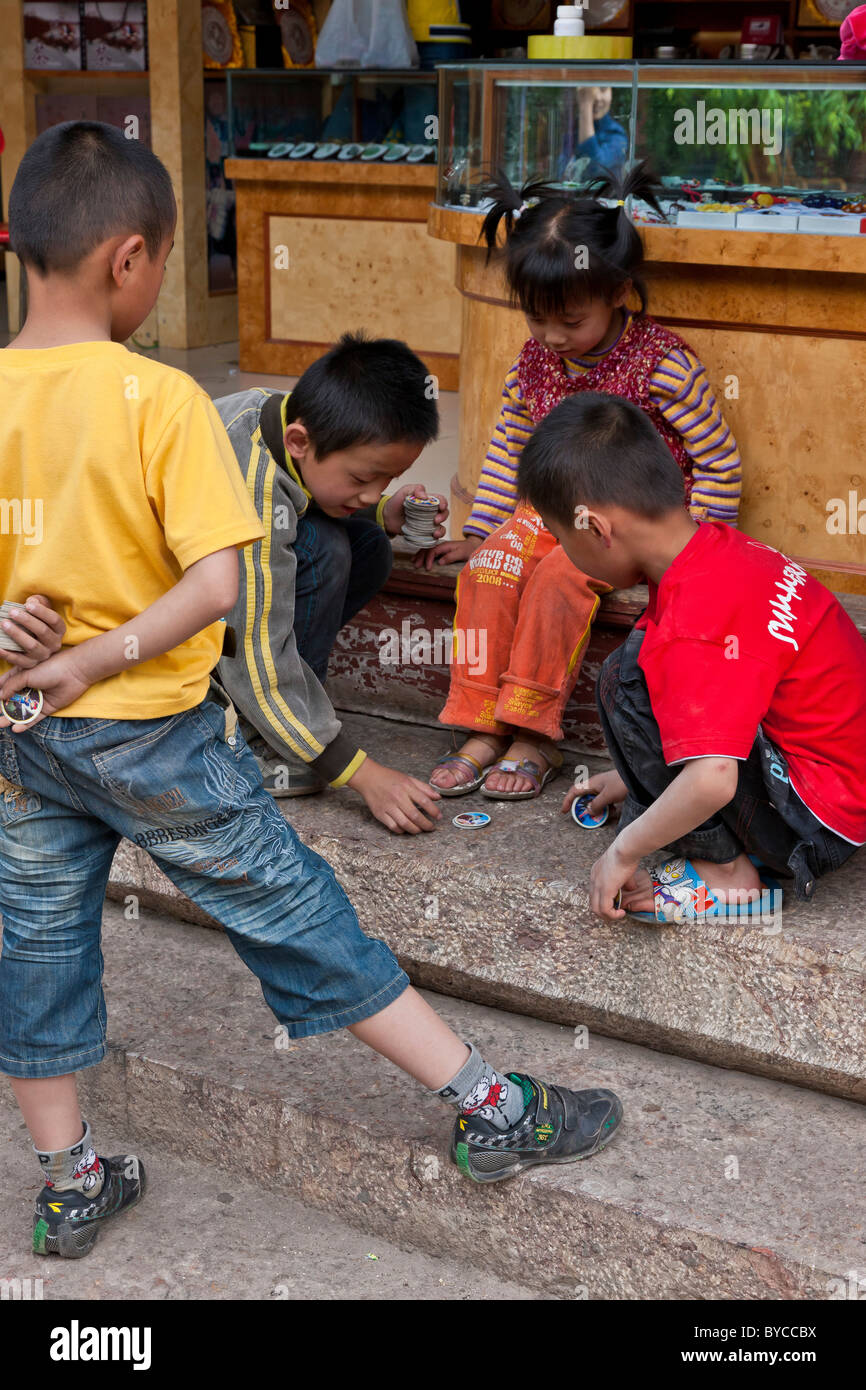 I bambini giocando nella piazza del vecchio mercato, Lijiang, nella provincia dello Yunnan in Cina. JMH4750 Foto Stock