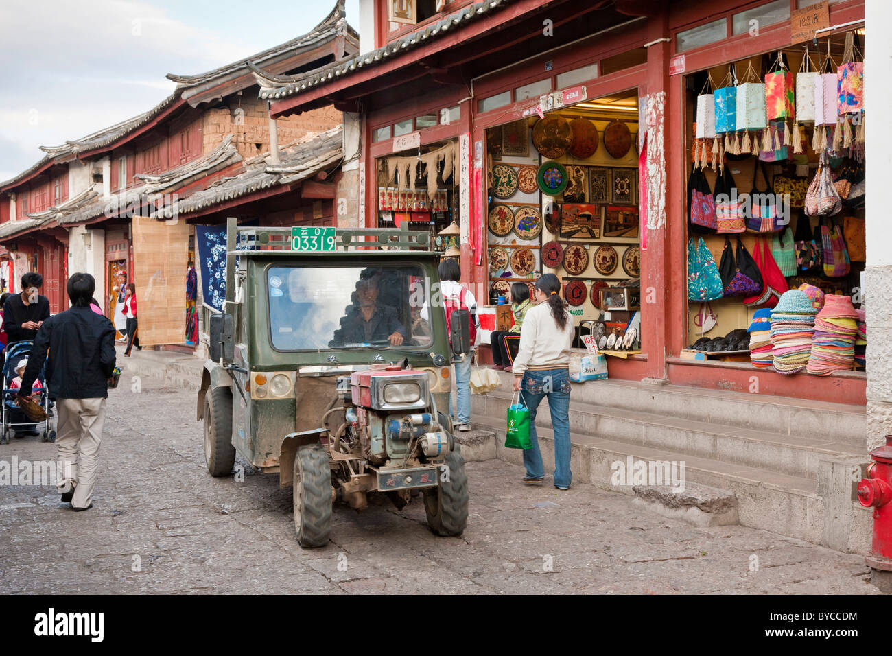 Un tuk-tuk, Riscio' o auto rickshaw in uno stretto vicolo lastricato a Lijiang old town, nella provincia dello Yunnan in Cina. JMH4757 Foto Stock