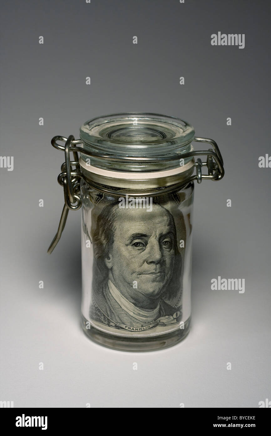 Mason Jar con un $100 bill all'interno mostra Benjamin Franklin del viso. Foto Stock