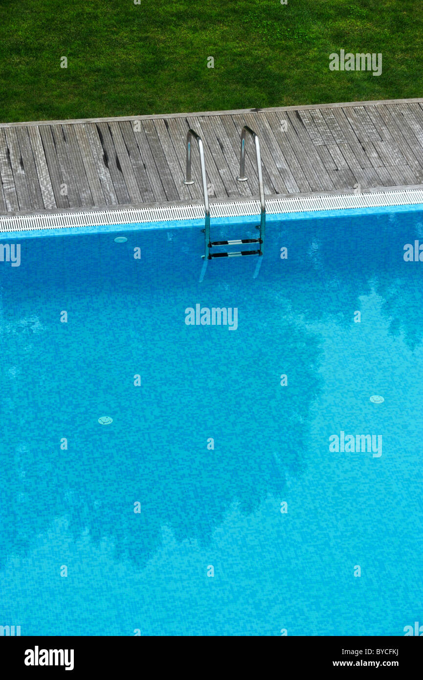 Vista aerea di una piscina esterna con ponte di legno e prato Foto Stock