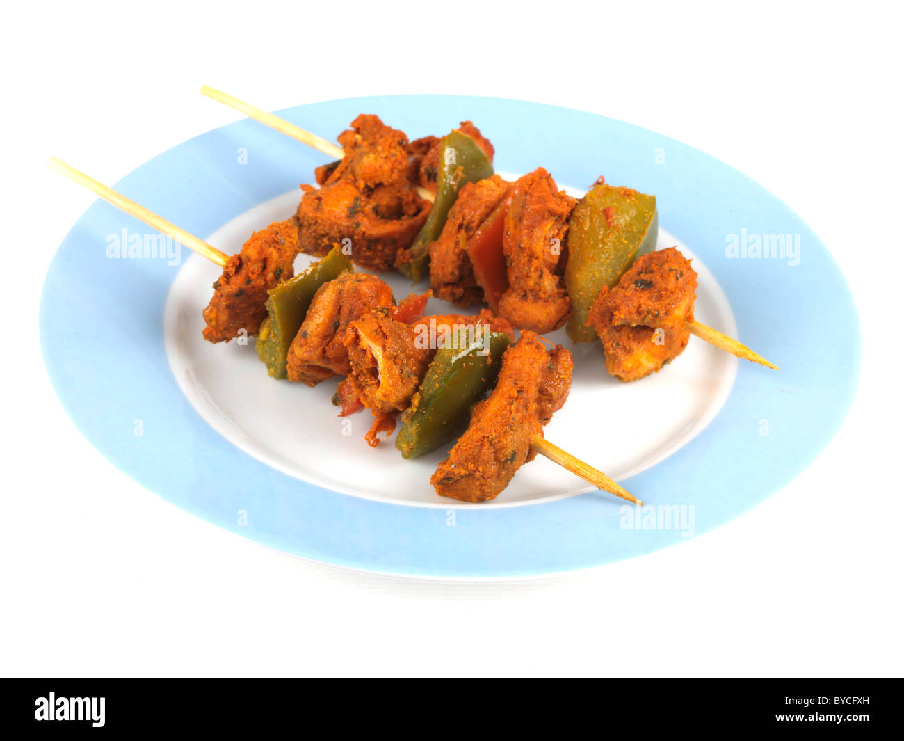 Appena cucinata o indiano stile Asiatico Pollo Tikka spiedini su spiedini contro uno sfondo bianco con nessun popolo e un tracciato di ritaglio Foto Stock