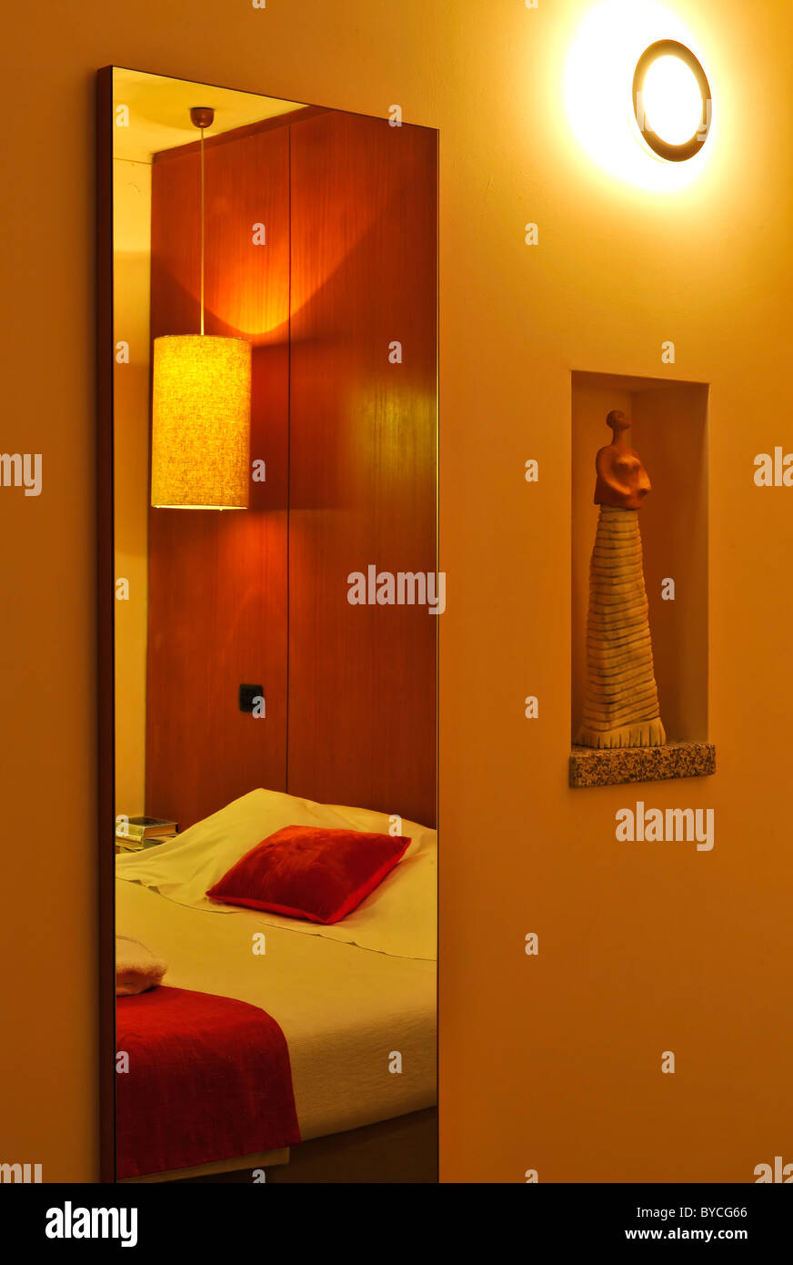 Bed riflessa nello specchio di una camera da letto con arredamento moderno Foto Stock