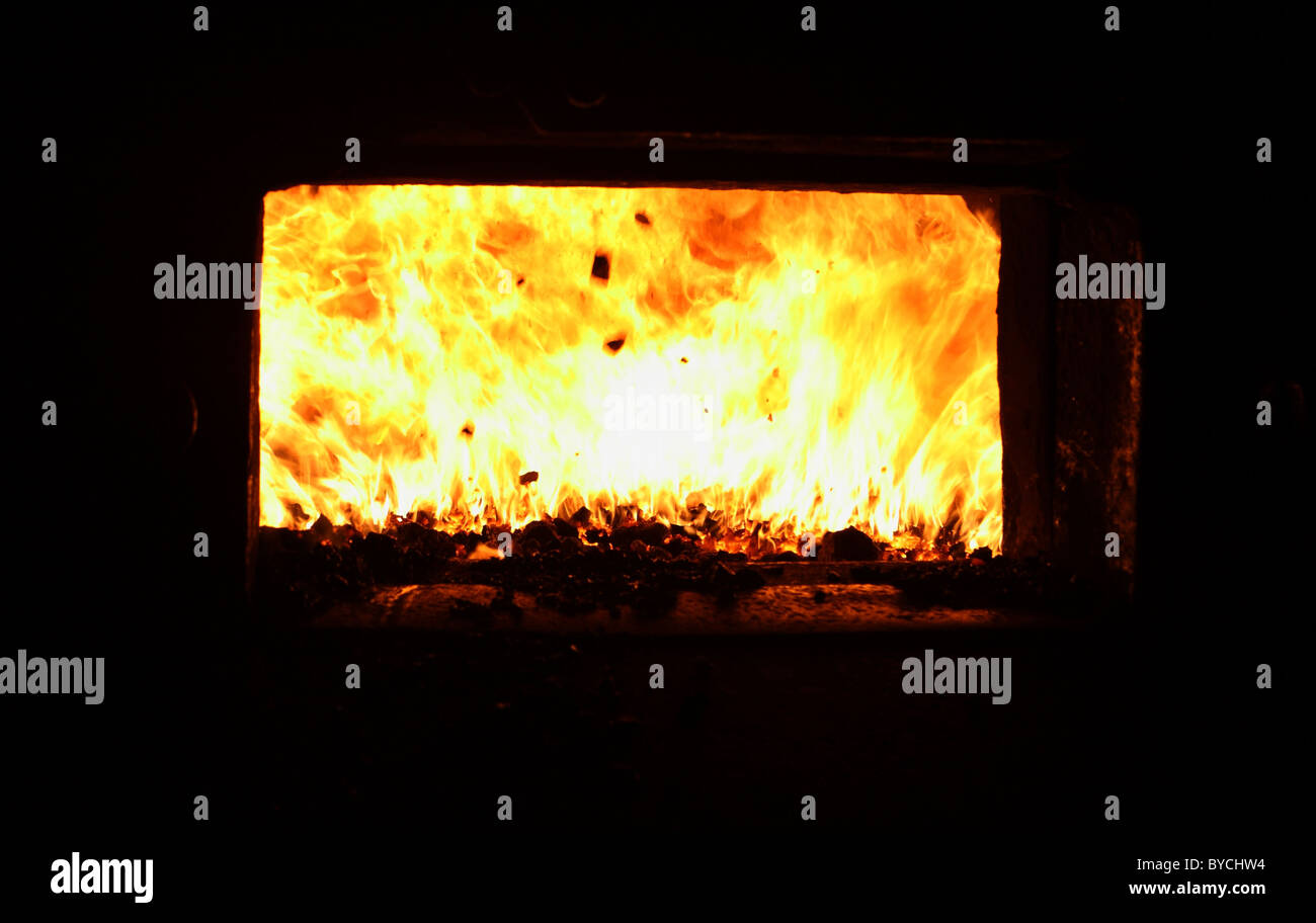 Intenso calore e fiamme nel fuoco della grata di una caldaia Foto Stock