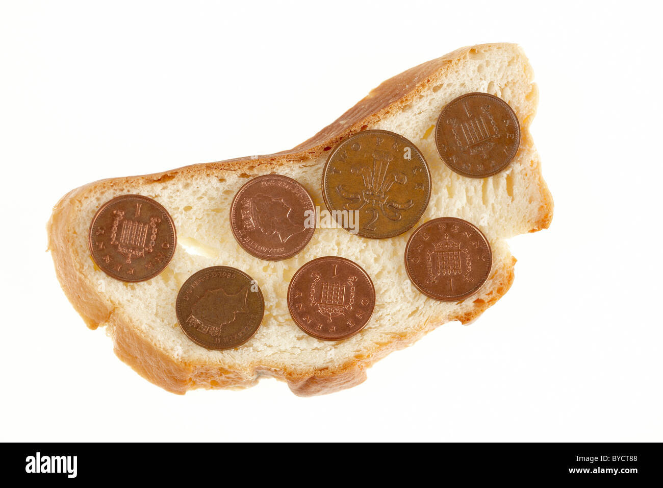 Fetta di pane raffermo con monete del Regno Unito su di esso. Foto Stock
