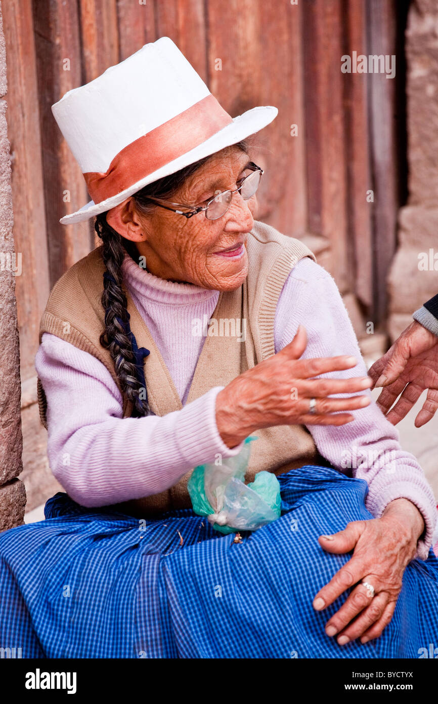 Signora anziana sat nel mercato di Pisac, Valle Sacra, Perù, Sud America. Foto Stock