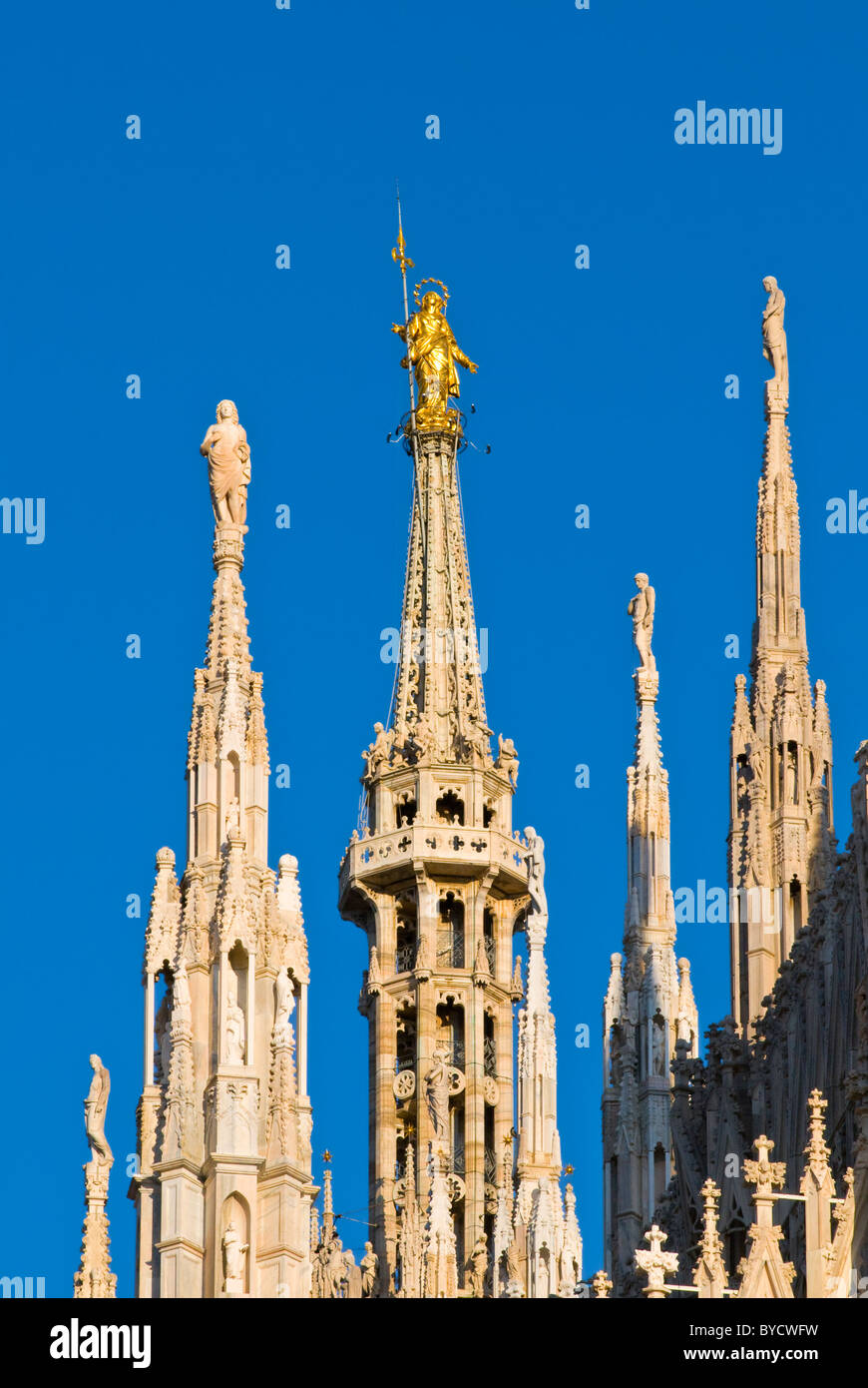 L'Italia, Milano, statua della Madonnina sulla guglia della cattedrale contro il cielo blu Foto Stock
