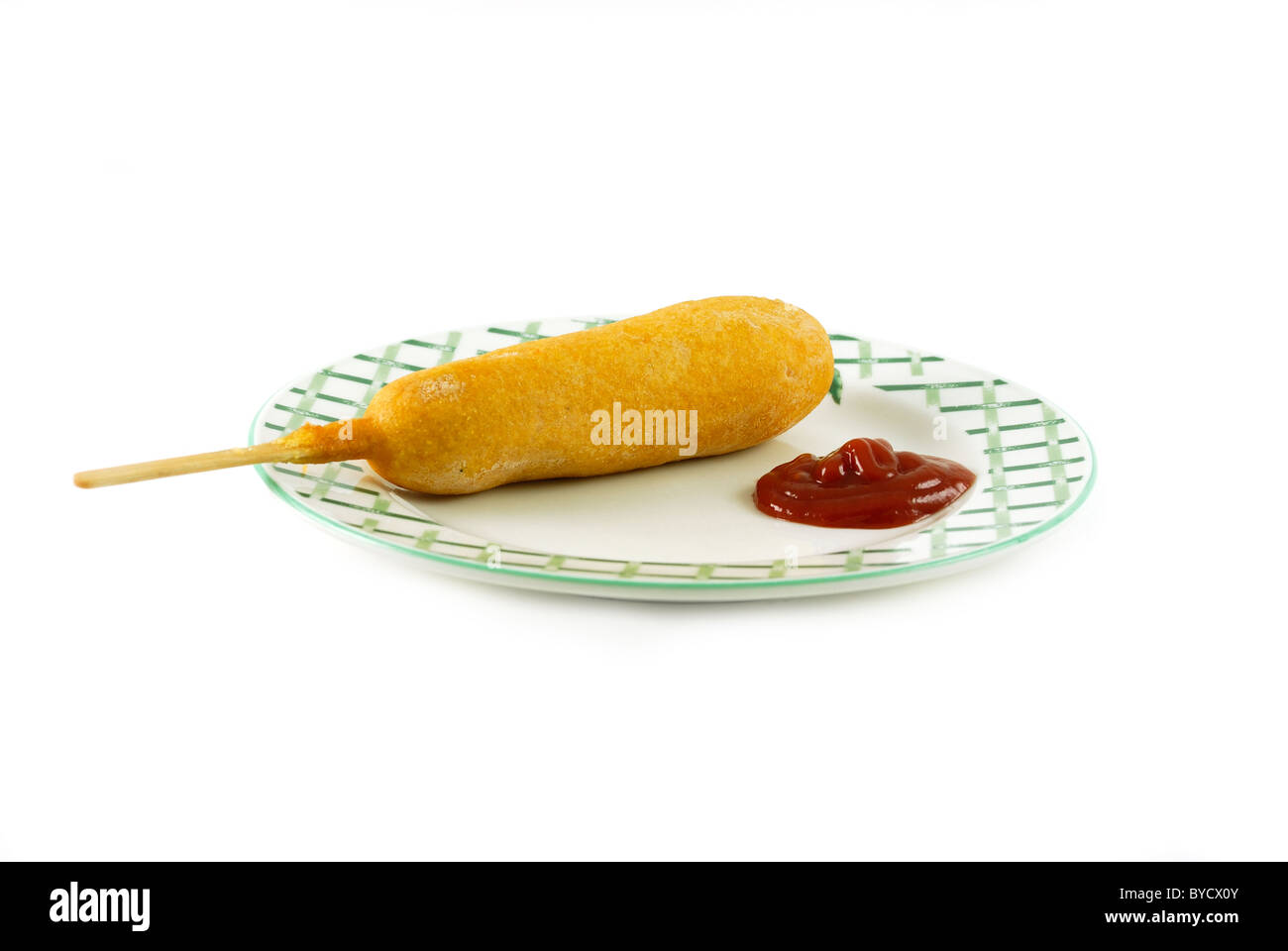 Cane di mais su una piastra con ketchup isolato su uno sfondo bianco Foto Stock