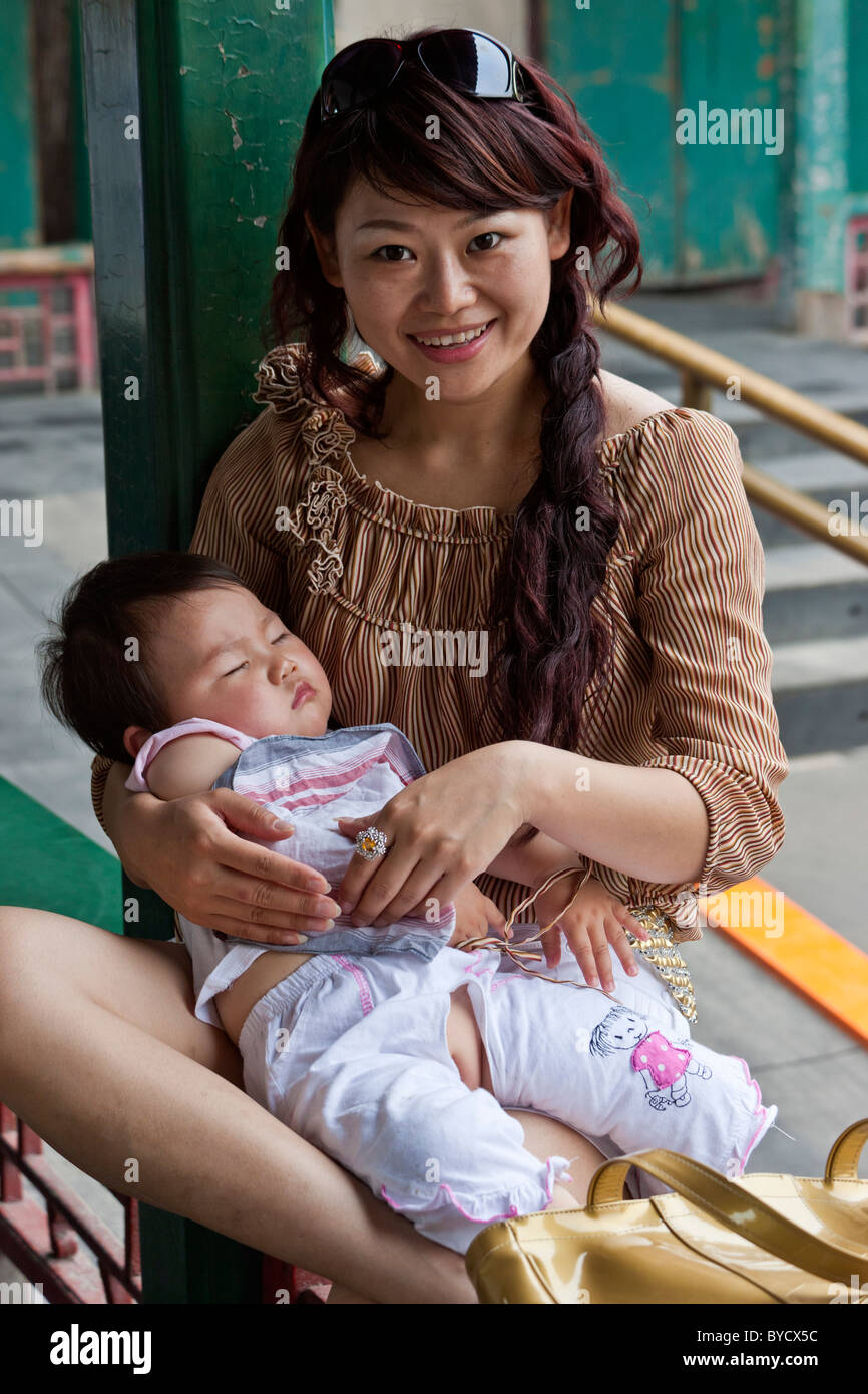 Bella sorridente giovane madre cinese e la sua bimba in i motivi del nuovo Palazzo Estivo, Pechino, Cina. JMH4805 Foto Stock