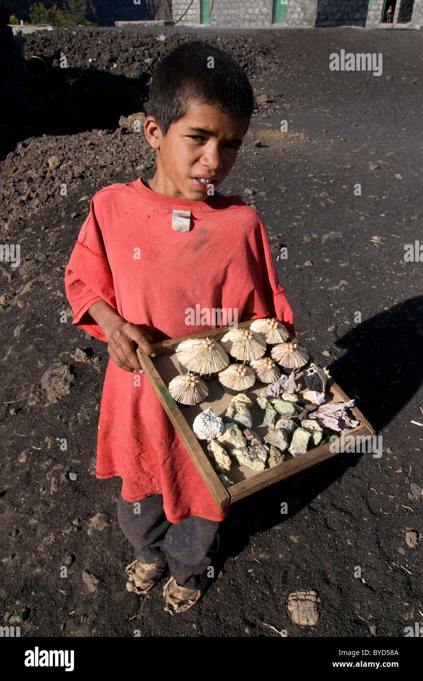 Il ragazzo nativo di vendere qualcosa davanti a casa sua vicino a un vulcano, Fogo, Cabo Verde, Africa Foto Stock