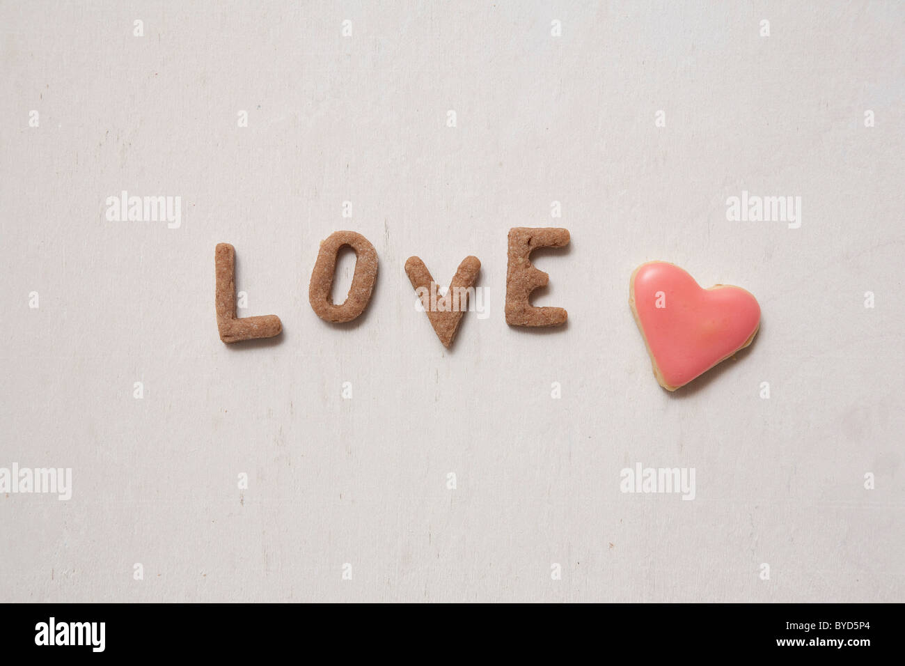 Amore e Parola scritta con biscotti, con un cuore di biscotto a forma di Foto Stock