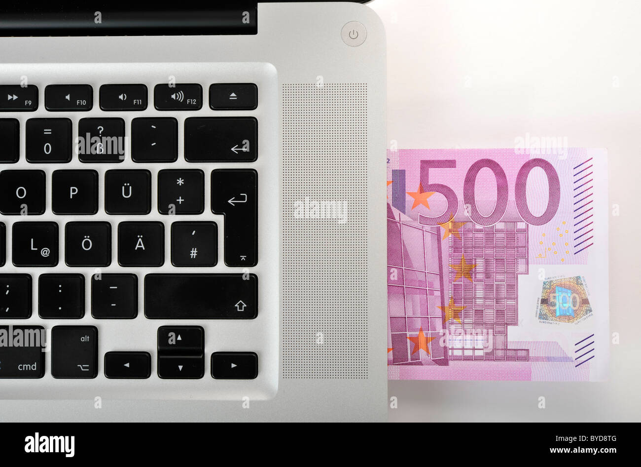 Notebook, PC, con una banconota da 500 euro Foto stock - Alamy