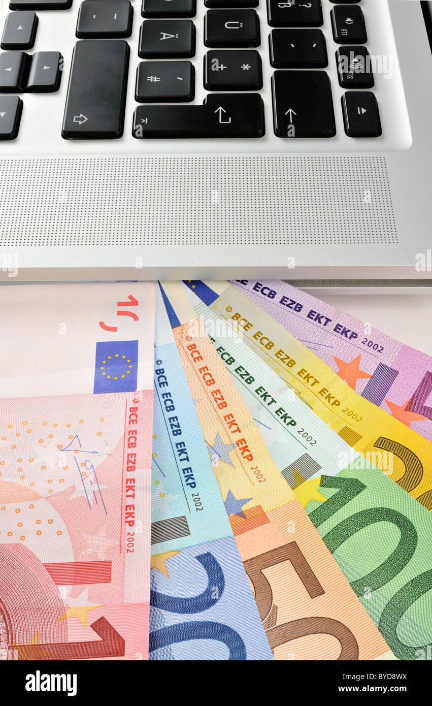 Notebook, PC, con una ventola di varie banconote in euro, immagine simbolica per aziende Internet e computer aziende Foto Stock