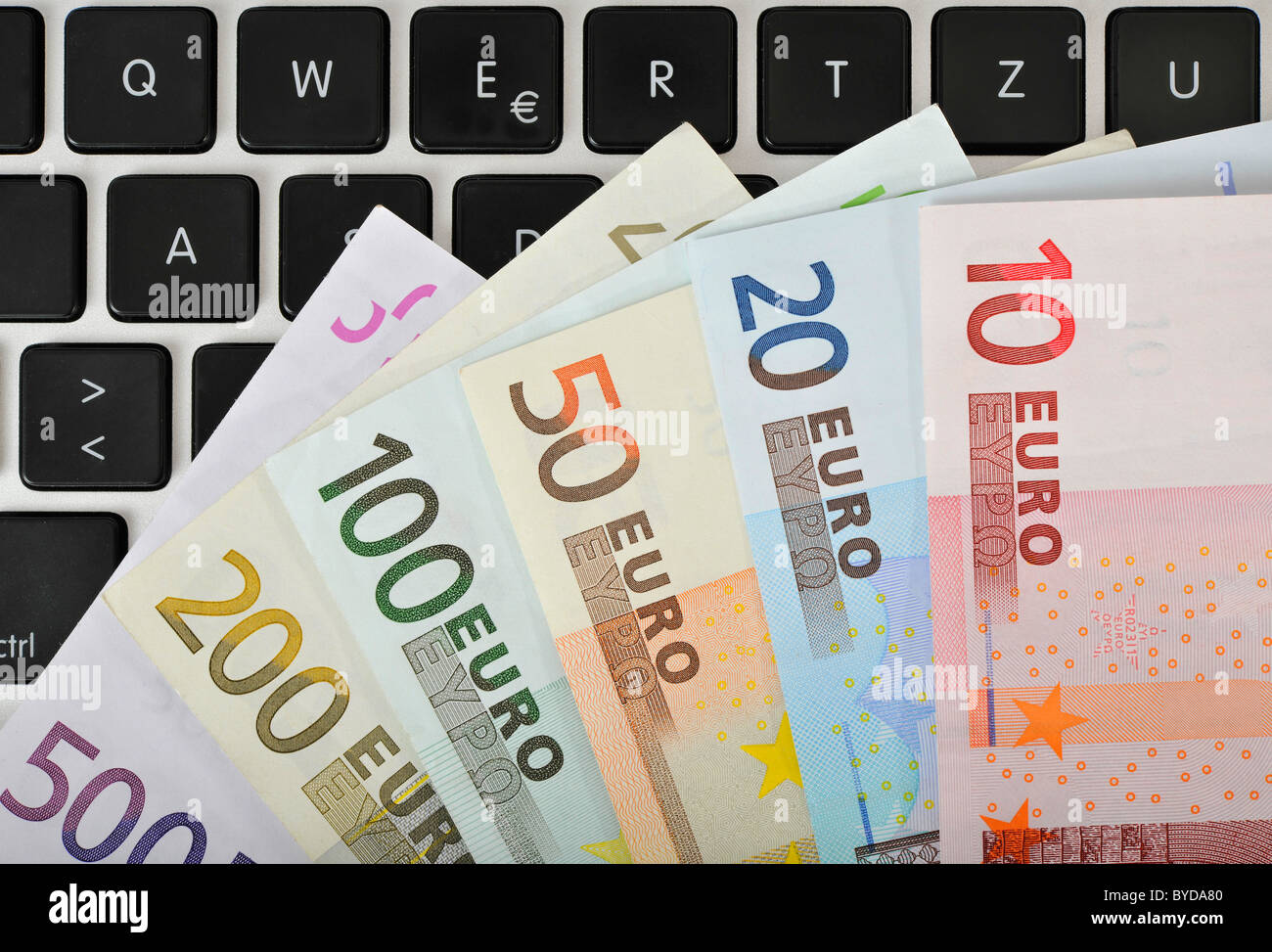 Fan di varie banconote in euro sulla tastiera di un PC portatile, immagine simbolica per aziende Internet e computer aziende Foto Stock