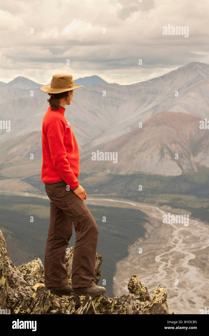 Giovane donna escursionismo, godendo del panorama, vista, Wind River Valley, nord montagne Mackenzie, Yukon Territory, Canada Foto Stock