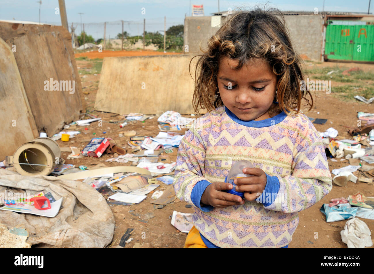 Ragazza, 8, giocando con un giocattolo che ha trovato presso il dump informale al di fuori della propria casa, la sua famiglia vive mediante la raccolta, la separazione e la Foto Stock