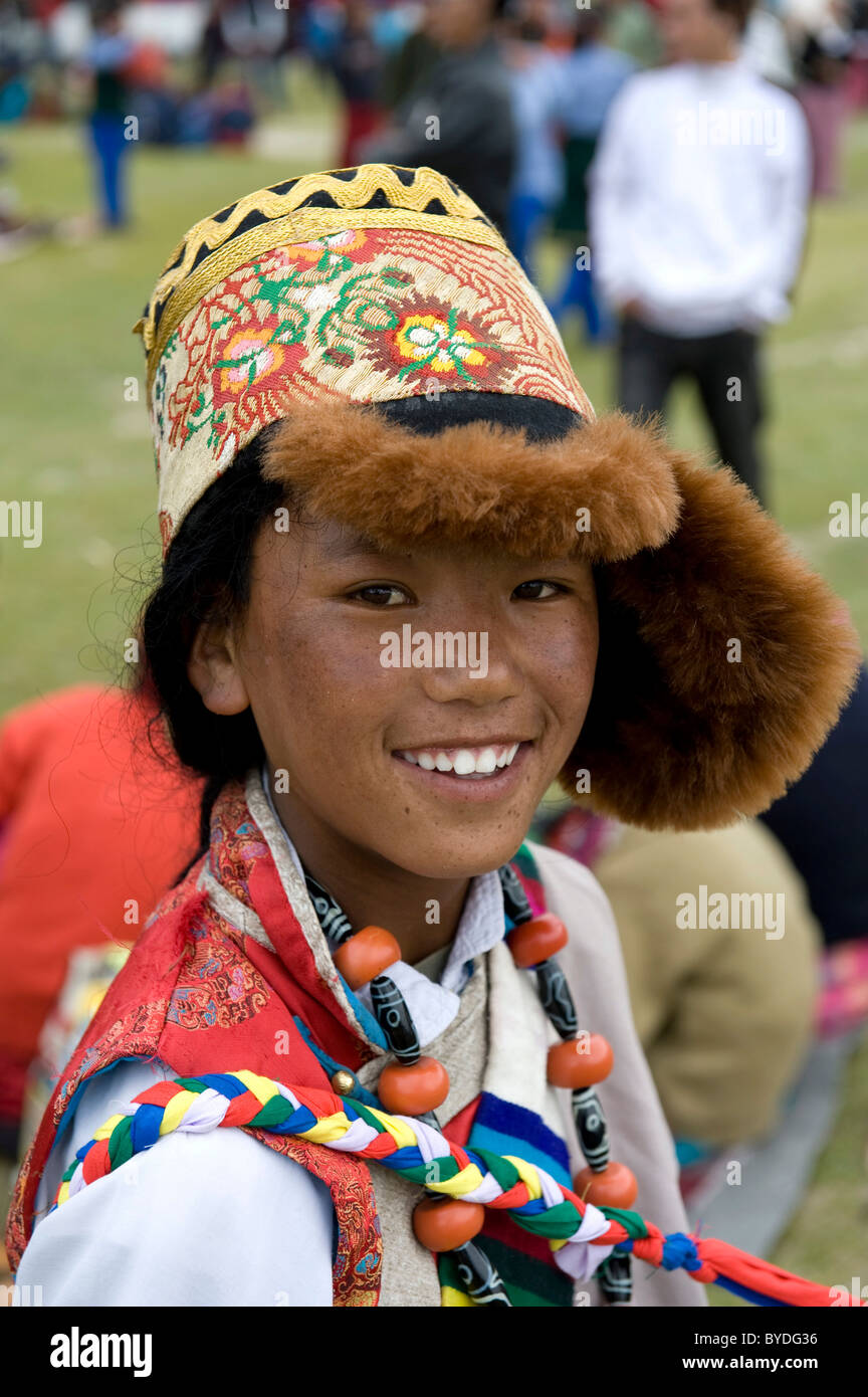 Ragazzo tibetano in tibetano abito tradizionale con un cappuccio grande, ritratto, sorriso, festival di Choklamsar vicino a Leh, regione del Ladakh Foto Stock